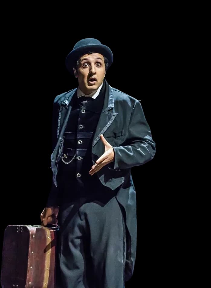 Charly Brahim en scène dans Le Maître du Temps, valise à la main